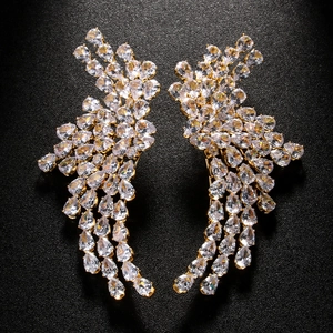 Macro shot of wing-shaped earrings with pear-cut cubic zirconia and gold plating