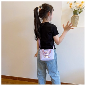 Detail view of the purple cartoon bunny shoulder bag worn by a child in a home setting