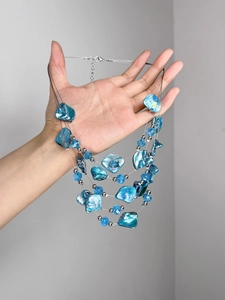 Détails du collier multi-rangs en perles bleues avec charmes de coquillages et fermoir homard
