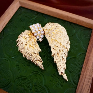 Vue détaillée d'une broche aile dorée avec strass scintillants au style vintage chic