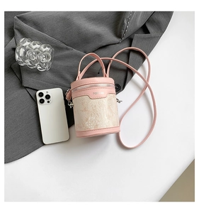 Detailed view of pink PU leather and jacquard fabric bucket bag with top handle and strap
