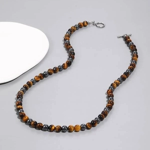 Detail of tiger eye and hematite beaded necklace with a stylish metal T-toggle clasp