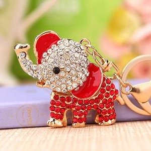Macro view of gold elephant keychain with red enamel ears and sparkling rhinestones