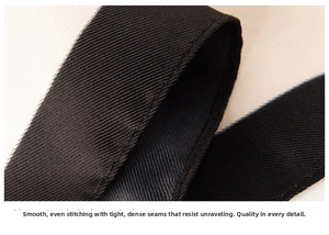 Detailed macro view of the neat fine stitching on the black woven silk scarf edges