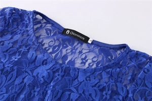 Detailed view of the dark blue lace dress neckline with a floral pattern and brand labels