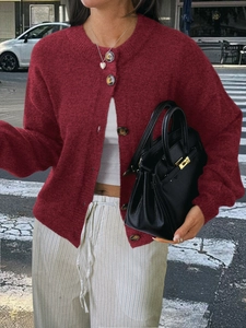 Gilet en maille rouge pour femme avec boutons, porté avec un haut blanc et pantalon