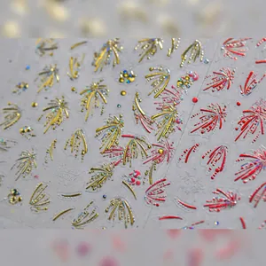 Vista macro di adesivi 3D metallici per unghie con fuochi d'artificio in oro e rosso lusso