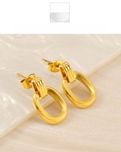 Detailed close-up of golden oval double-loop earrings with textured ridge accents