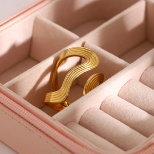 Macro shot of 18k gold plated stainless steel ring with wave texture on pink velvet