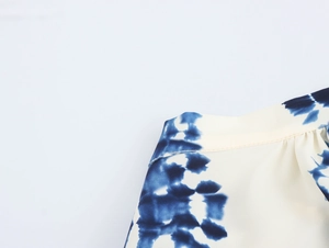 Detailed macro view of the blue and white tie-dye chiffon fabric with fine stitching
