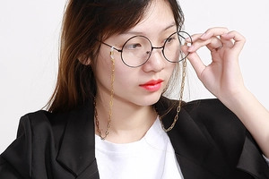 Close-up of golden titanium link eyewear chain on black frame glasses with non-slip loops
