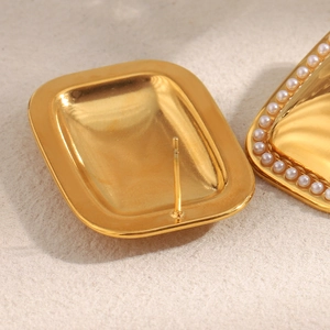 Macro shot of 18K gold plated rectangular earrings with delicate small pearls edge