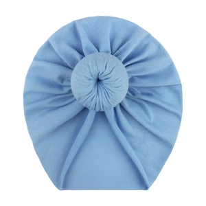 Detailed macro view of soft blue knitted baby turban hat with a knotted doughnut design