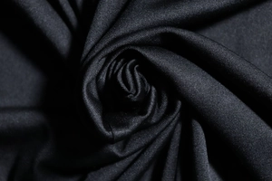 Macro shot of high-quality black pleated fabric texture folded into a rose shape
