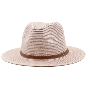 Close-up of pink straw fedora hat featuring fine woven texture and brown leather strap