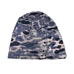 Close-up of blue and white camo knit beanie showing distressed holes and fabric texture