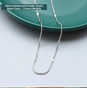 Detail view of a 1.3mm wide steel embossed snake bone chain necklace in minimalist style