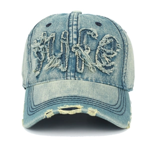 Détail de la broderie WIFE et des trous effilochés sur la casquette en denim usé