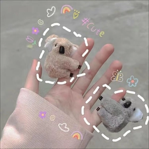 Close-up of cute plush koala hair clips in brown and grey with soft fuzzy texture