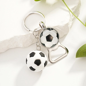 Soccer ball keychain with silver metal bottle opener on white textured stone background