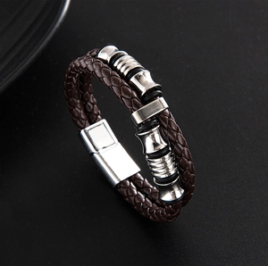 Detail of brown braided leather bracelet with silver magnetic clasp and metal beads