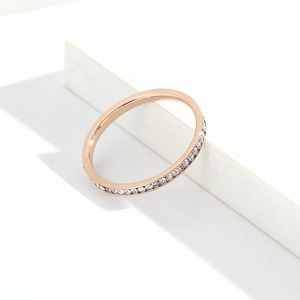 Vue détaillée d'une bague en acier inoxydable or rose avec cristaux micro-pave et finition.