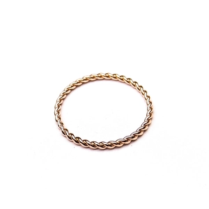 Macro detail of rose gold twisted rope ring with a polished minimalist aesthetic