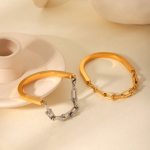 Détail de bracelets à maillons fer à cheval en or et argent sur fond minimaliste