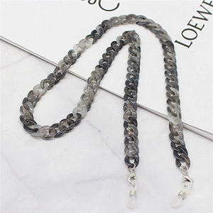 Macro detail of marble-patterned acrylic chain links with silver metal lobster clasps