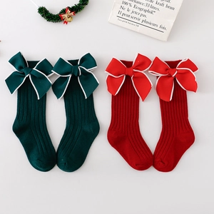 Green and red Christmas baby high socks with large bow ties and ribbed knit texture