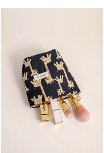 Detail of navy giraffe jacquard cosmetic bag with flower charm and golden zipper