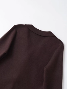 Détail du dos d'un blazer en maille marron foncé montrant les coutures du col et la texture