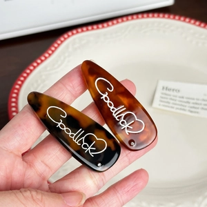 Mollette per capelli francesi in acetato tartarugato con scritta Good Luck e un cuore