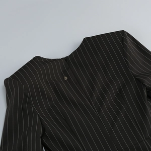 Detail of pinstripe dress featuring a concealed zipper and vintage metallic button fastener