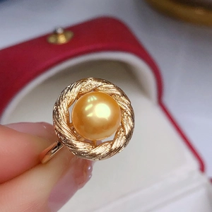 Elegant gold-tone ring featuring a large golden freshwater pearl on a twisted band