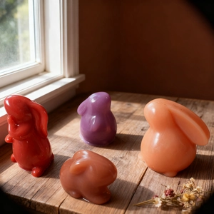 Set of four colorful Easter rabbit decorative candles in red, purple, pink and brown