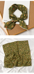 Detail of olive green square silk scarf with floral print and white hemmed edges