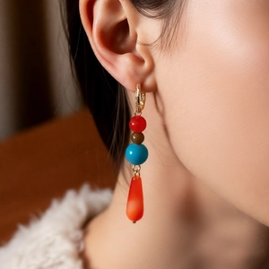 Detail of beaded drop earrings with colorful stones on model for a bohemian look