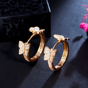 Detail shot of golden butterfly earrings with sparkling cubic zirconia on dark background