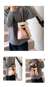 Detailed view of pink suede bucket bag with white faux fur trim and drawstring closure