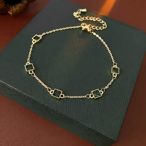 Elegant gold plated chain bracelet featuring square emerald green zircons and adjustable clasp