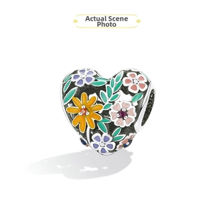 Macro detail of S925 silver heart charm with colorful enamel flowers and zircons