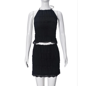 Detail of black pleated fabric with lace trim on halter top and mini skirt set