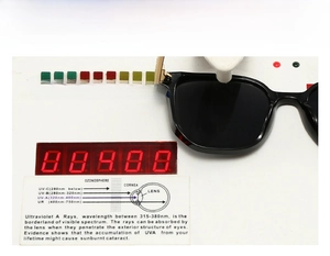 Detail shot of black aviator sunglasses on UV400 tester showing high protection level