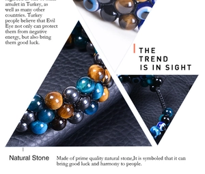 Macro detail of natural tiger eye beads and evil eye charm on triple braided bracelet