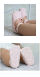 Detailed view of pink baby socks with lace trim and non-slip crown silicone grip