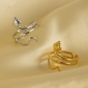 Minimalist 18K gold and silver snake spiral rings on gold silk background
