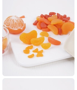 Detailansicht von realistischen PVC-Orangenspalten und geschälten Früchten auf Tablett