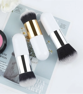 Detail of three rounded foundation brushes with white handles and dual-tone fiber bristles