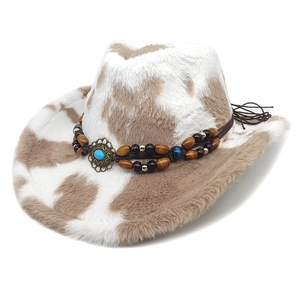 Détail du chapeau de cowboy en peluche imprimé vache avec perles et turquoise